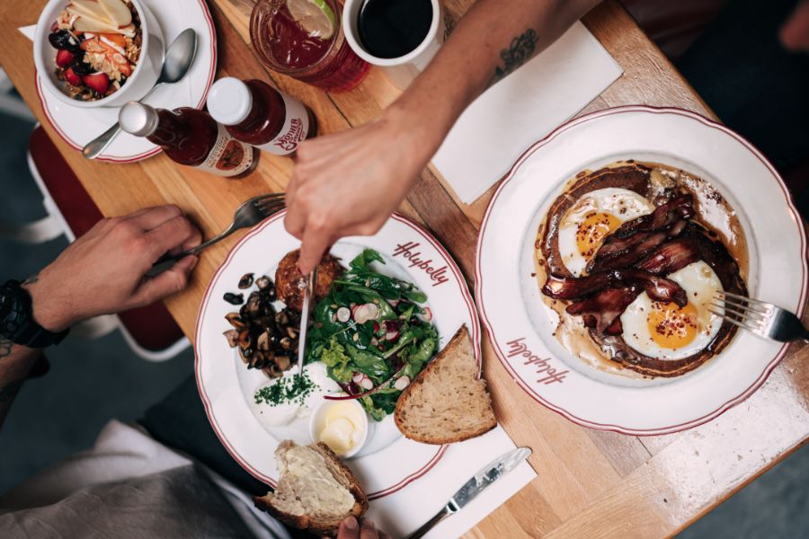 This is an image of a really nice breakfast spread where people are digging in with their knives and forks.