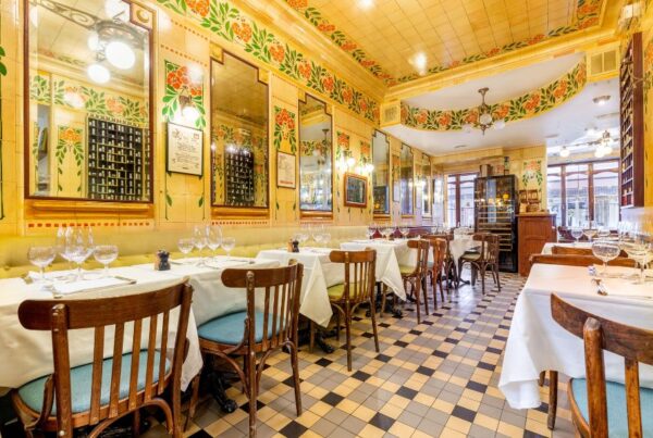 This is an image of a very bright yellow restaurant full of eccentric art and set tables.