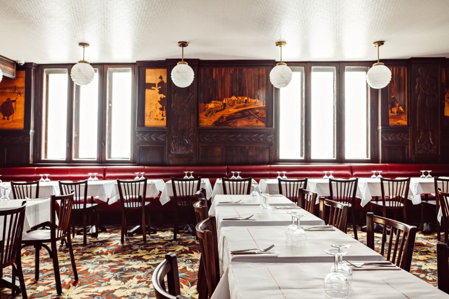 This is an image of a restaurant with white-clothed tables scattered across the room.