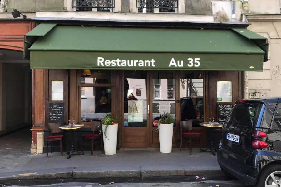 This is an image of a restaurant exterior with a green blind that says 'Restaurant Au 35'