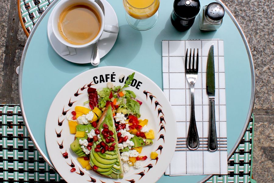 This is an image of a table at Cafe Jade full of a vegetarian breakfast, OJ and a cup of coffee.