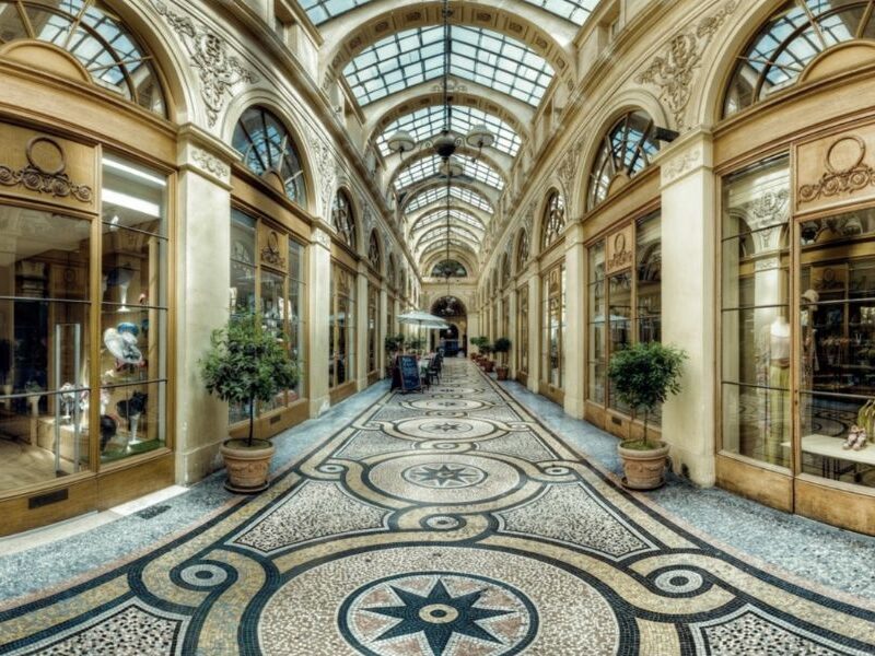 This is an image of Galerie Vivienne, which is a passageway with plenty of shops and lovely tiled floors. It looks very regal.