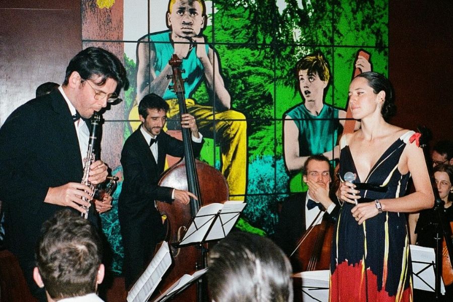 This is an image of a band on stage with a lead singer at the front performing to a crowd.