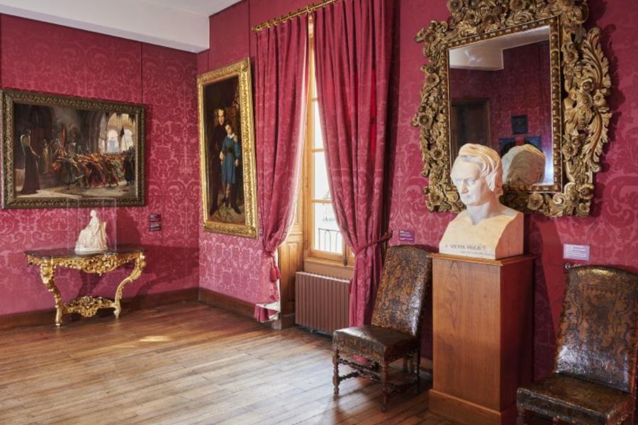 This is an exhibition room with old Parisian memorabilia and renaissance paintings on the wall.