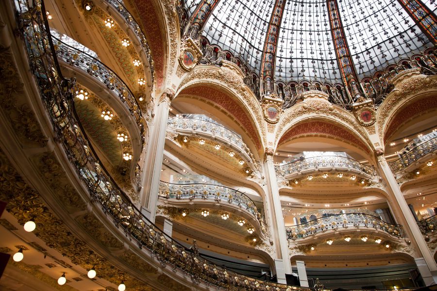 The spectacular interior of Galeries Lafayette, looking up at the ornate Art Nouveau balconies and stained glass dome