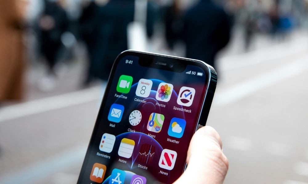 A person is holding a phone with apps showing.