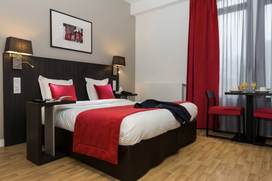 This is an image of a Paris hotel room with a double bed.
