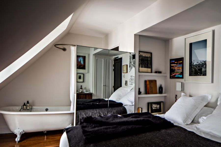 This is an image of a nice hotel room with a double bed and a standalone bath.