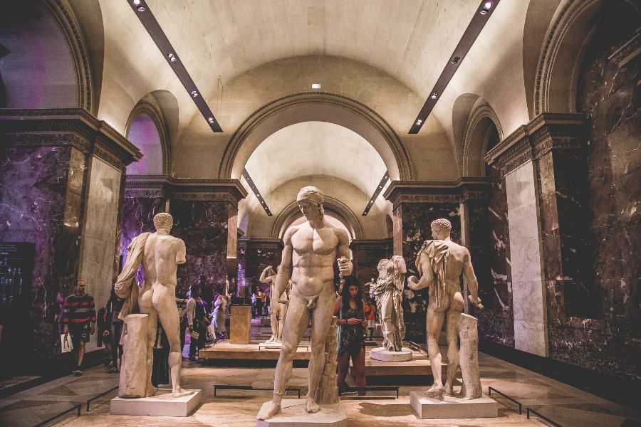This is an image of a room in The Louvre where there are plenty of male sculptures.