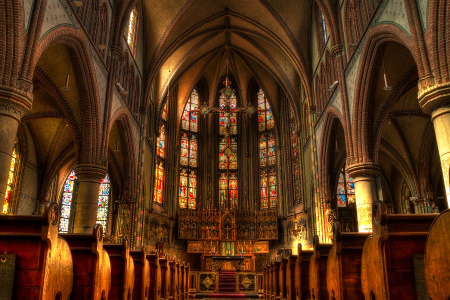 This is a picture of the interior of a beautiful church with high ceilings and stained-glass windows.