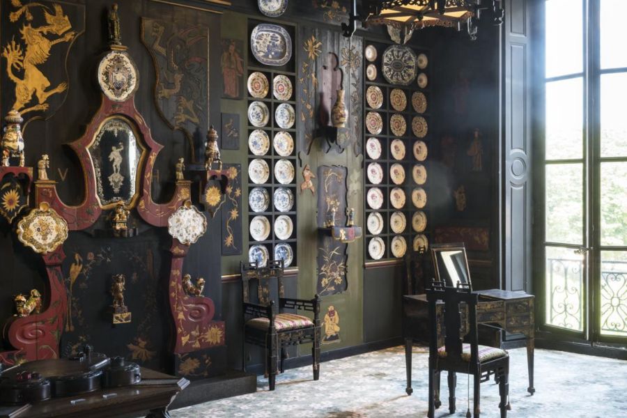 This is an image of an old room filled with memorabilia and old vintage items from Victor Hugo's estate. There is a big window that showcases a view of the Marais too.