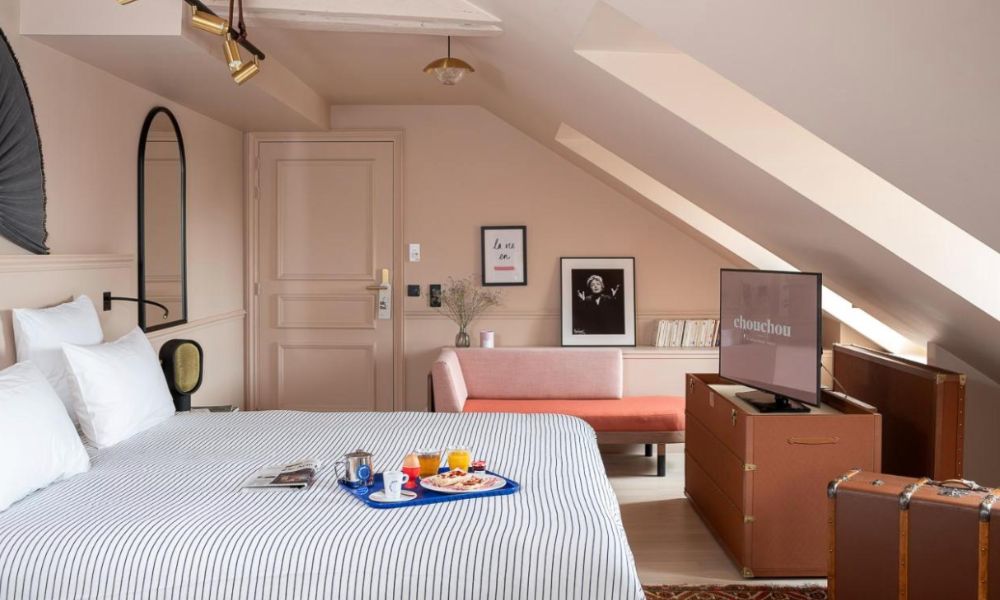 Best Paris hotels for solo travelers: This is an image of a chic hotel room with coloured decor and bed sheets that all work seamlessly together.