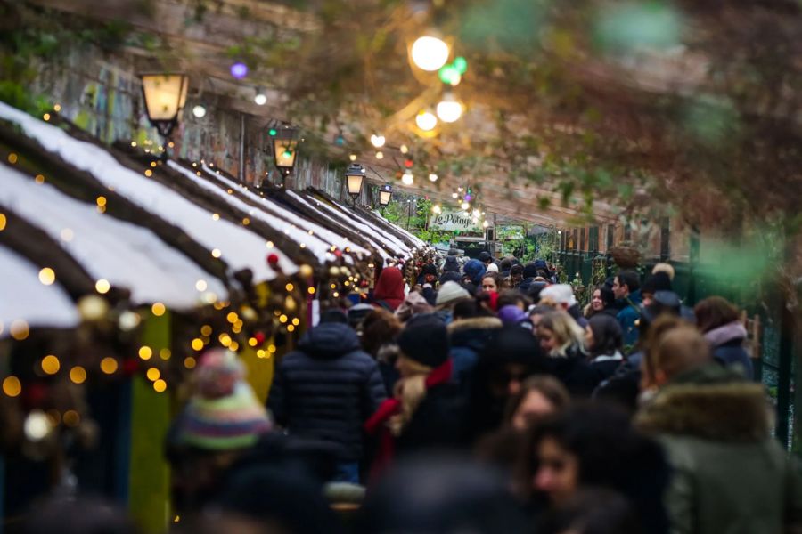 This is an image of a big row of Christmas markets and crowds of people walking through to see them.