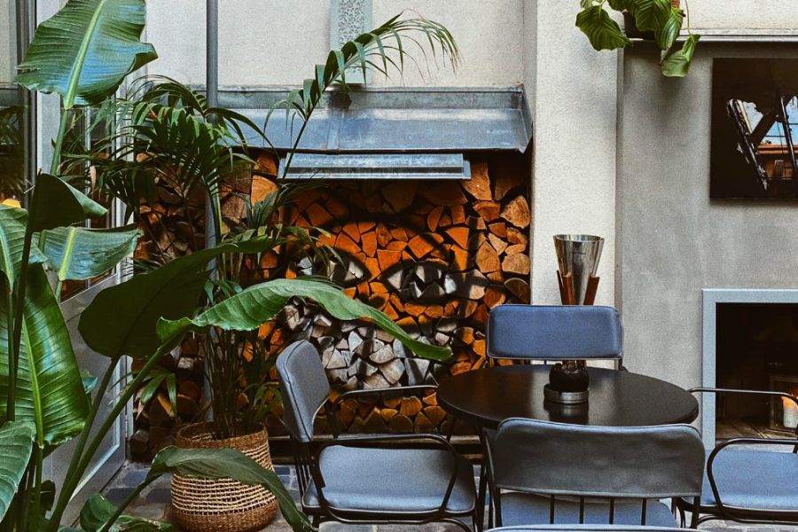 This is an image of an outdoor terrace with an open fireplace and cozy mood lighting.