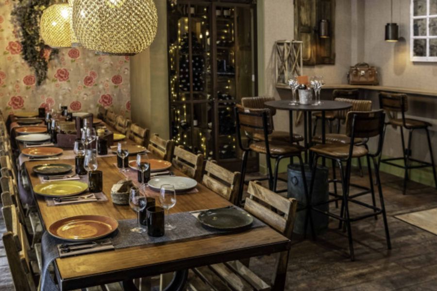This is an image of a small, cozy establishment with nice mood lighting and tables that are close to one another.