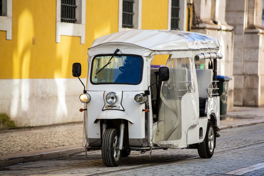 This is an image of a pedicab parked up by the side of the road with no one in it.