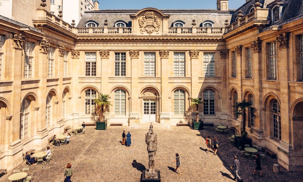 This is an image of a beautiful courtyard milling with people.