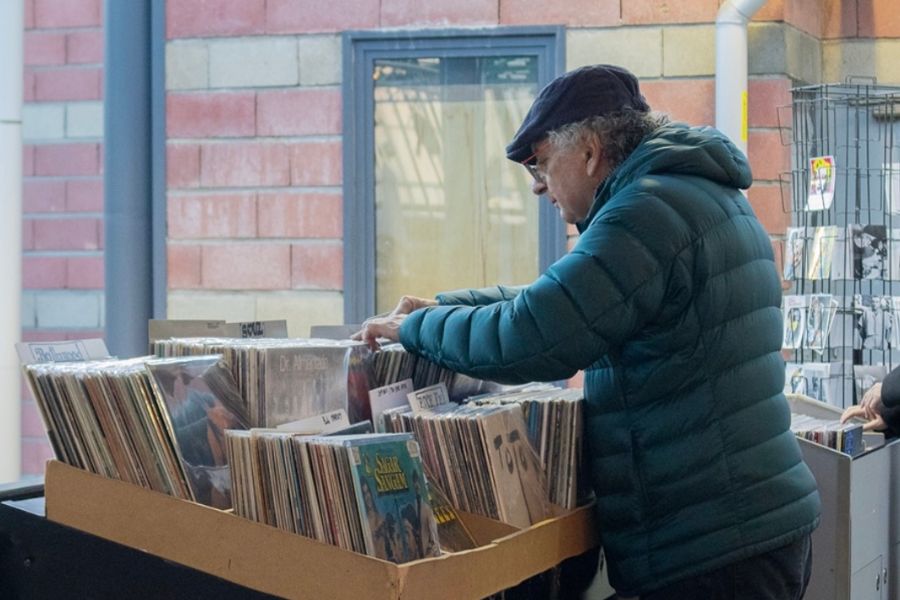 This is an image of a man looking through a collection of vinyls.