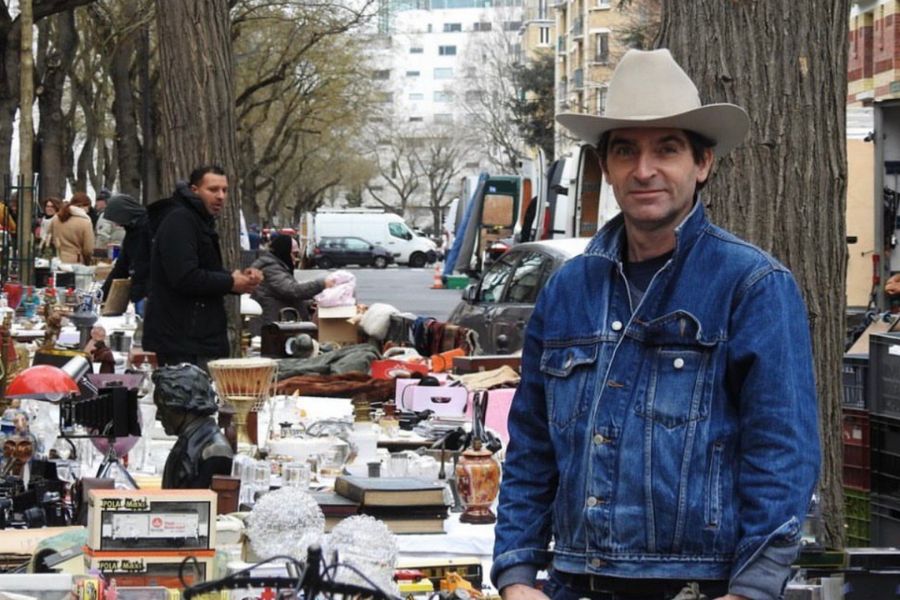 This is an image of a man standing proudly in front of a stall.