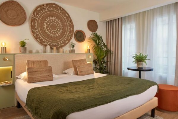This is an image of a boho-style bedroom with lot of greenery and straw decor.