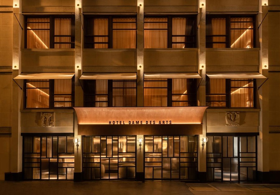 This is an image of the outside of a luxurious hotel with lots of windows on the front.