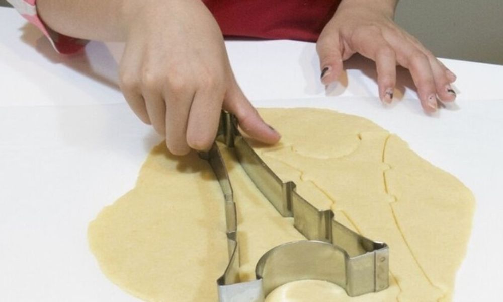 This is an image of a person who has cut cookie dough with an Eiffel tower-shaped cutter.
