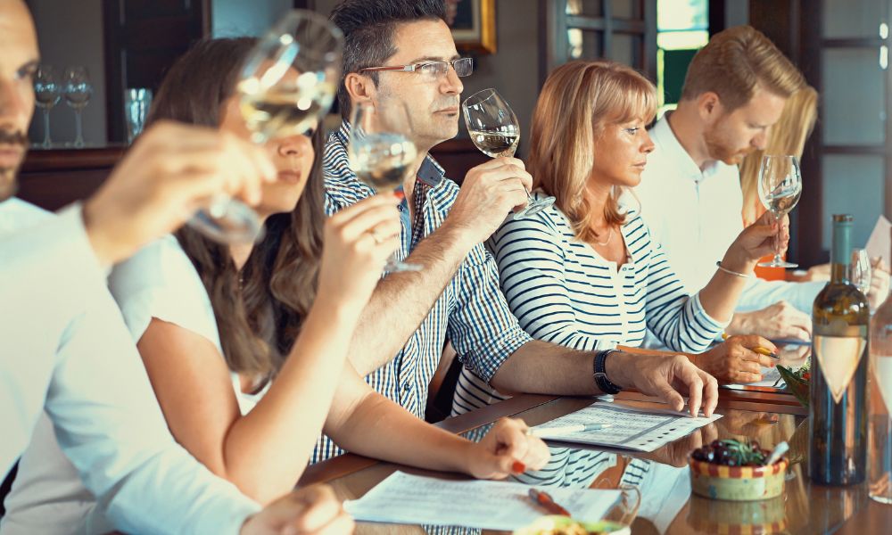 This is an image of a tour group doing a wine tasting smelling and trying their wine glasses.