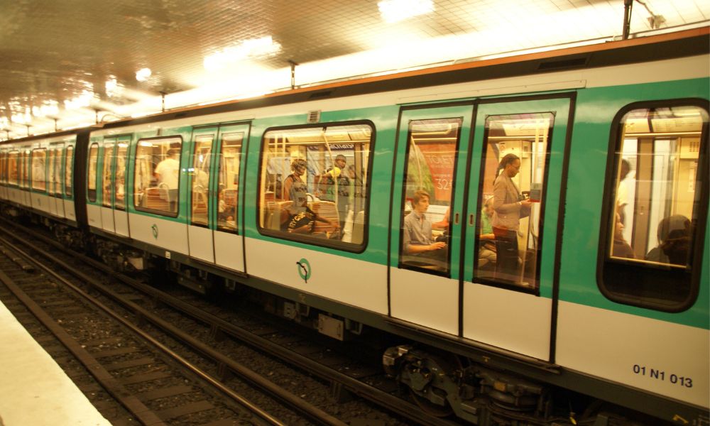 Things you should know before visiting Paris: This is an image of a Paris metro train on the tracks.