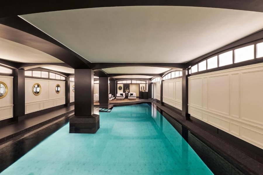 A bright blue pool with dark and white accents all around.