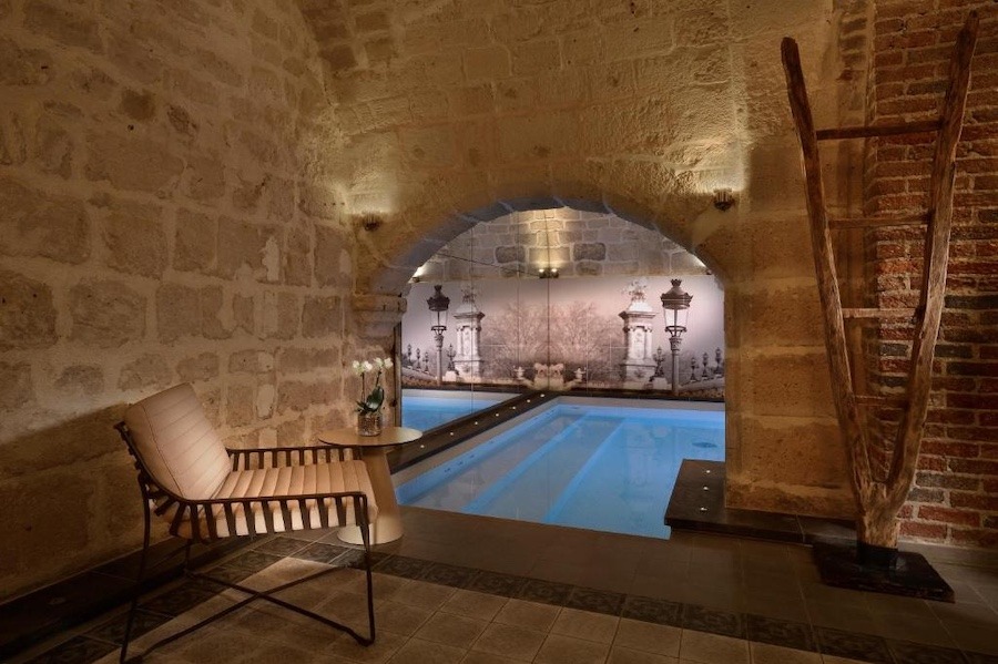 Picture shows a cave pool, surrounded by stone.