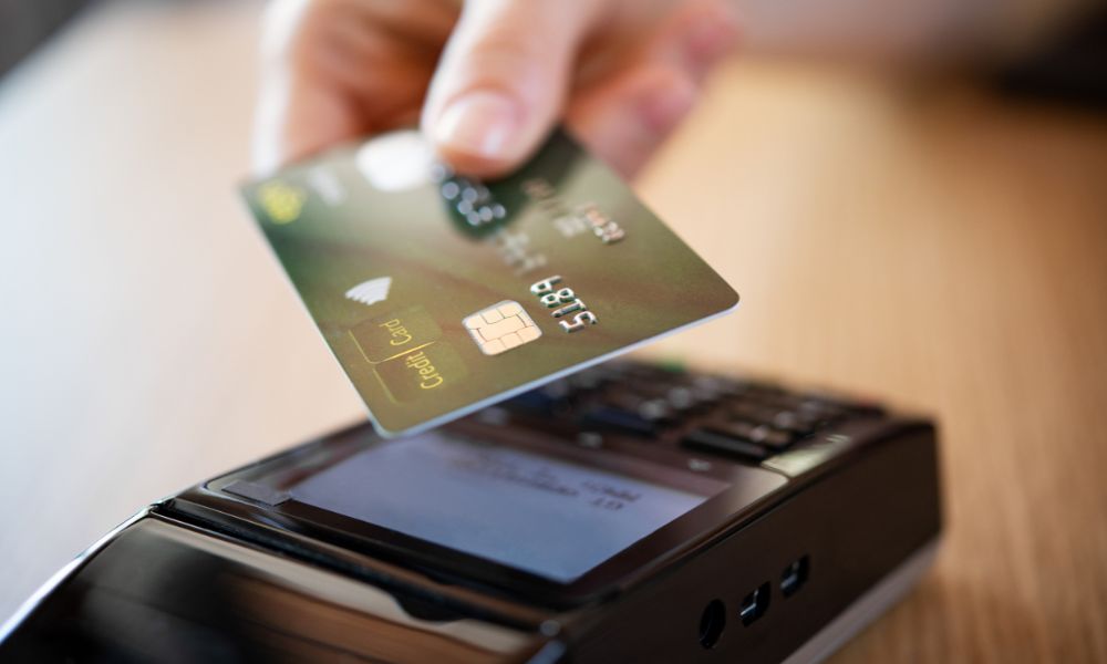 This is an image of a person tapping their card on an eftpos machine.