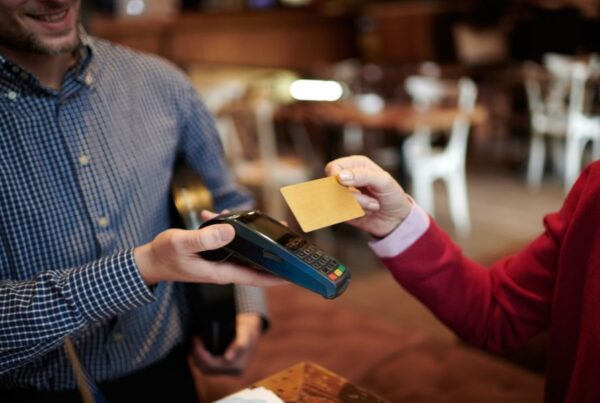How to avoid fees when using your card in Paris: This is an image of a person tapping their card on an eftpos machine.