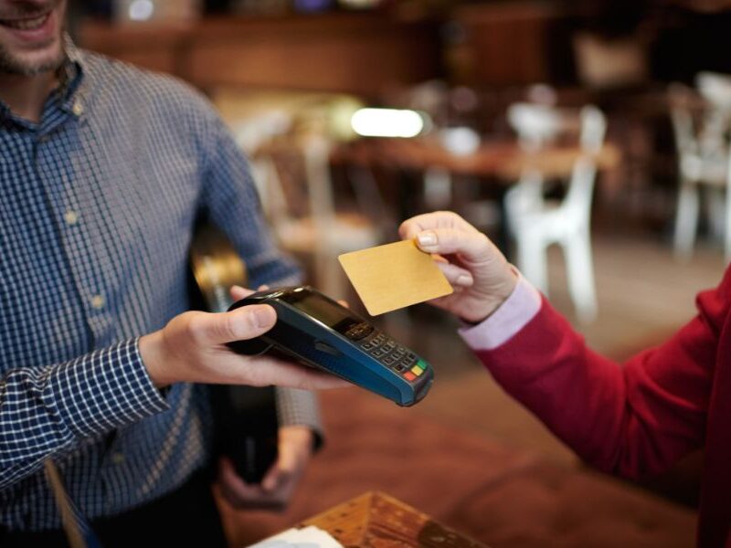 How to avoid fees when using your card in Paris: This is an image of a person tapping their card on an eftpos machine.
