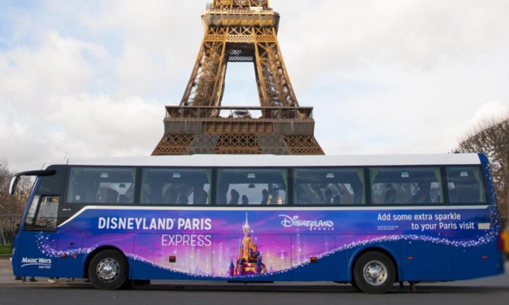 This is an image of the Disneyland Magic Bus parked in front of the Eiffel Tower.