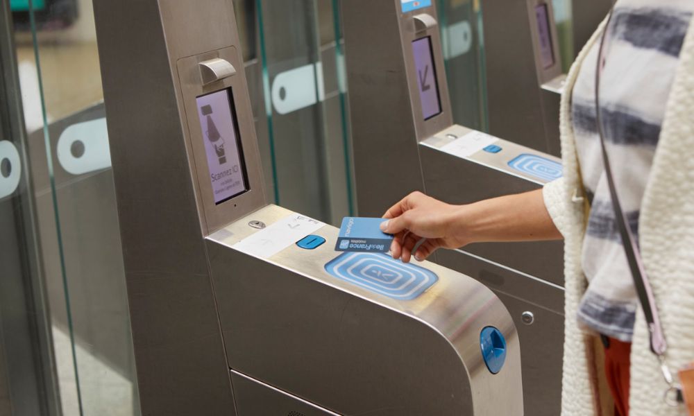This is an image of a lady tapping her Navigo Easy card on the barriers at a Paris train station.
