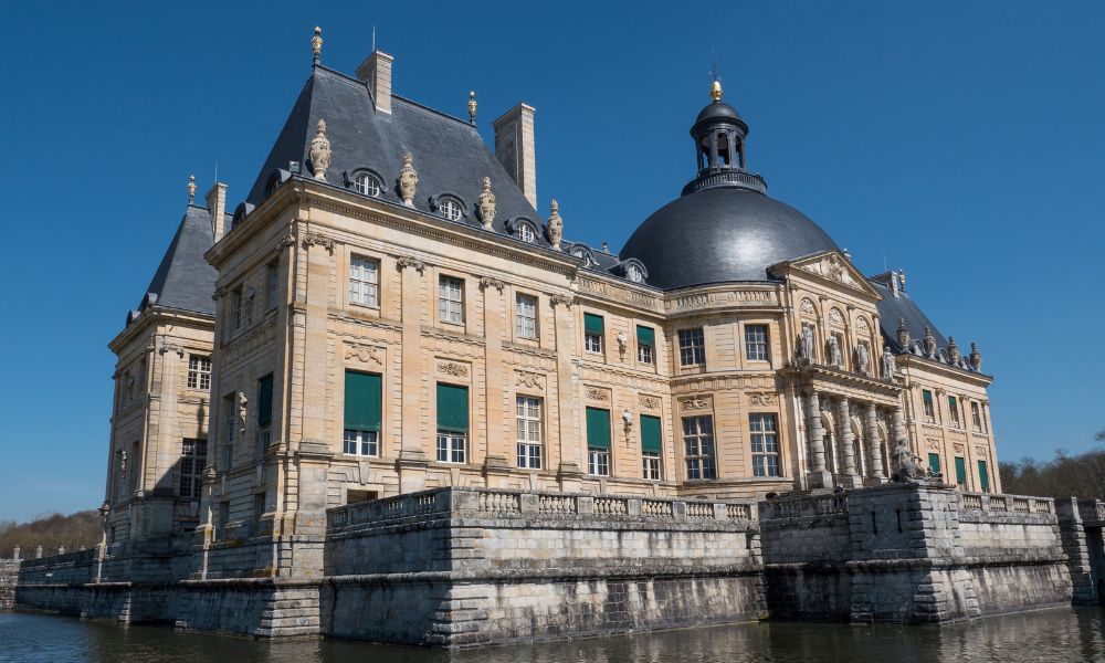 This is an image of an old, traditional castle with a moat around it.
