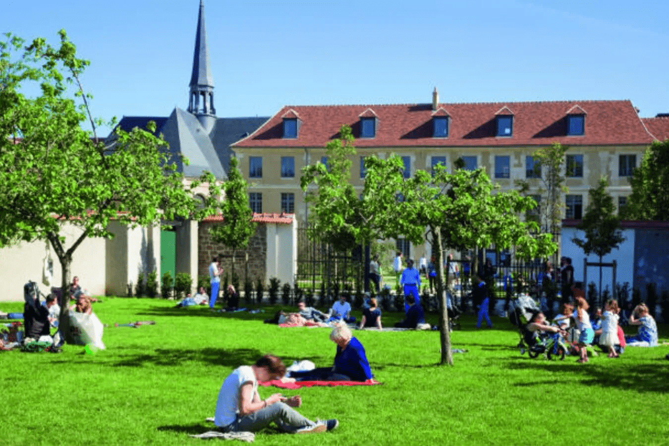 People sitting on the grass in a lush green garden on a sunny day in Paris.