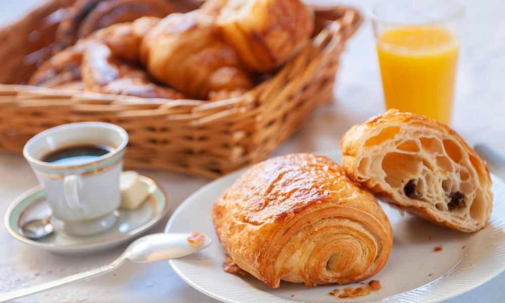 Paris hotel advice: This is an image of a few pastries, an OJ and a coffee on a table.