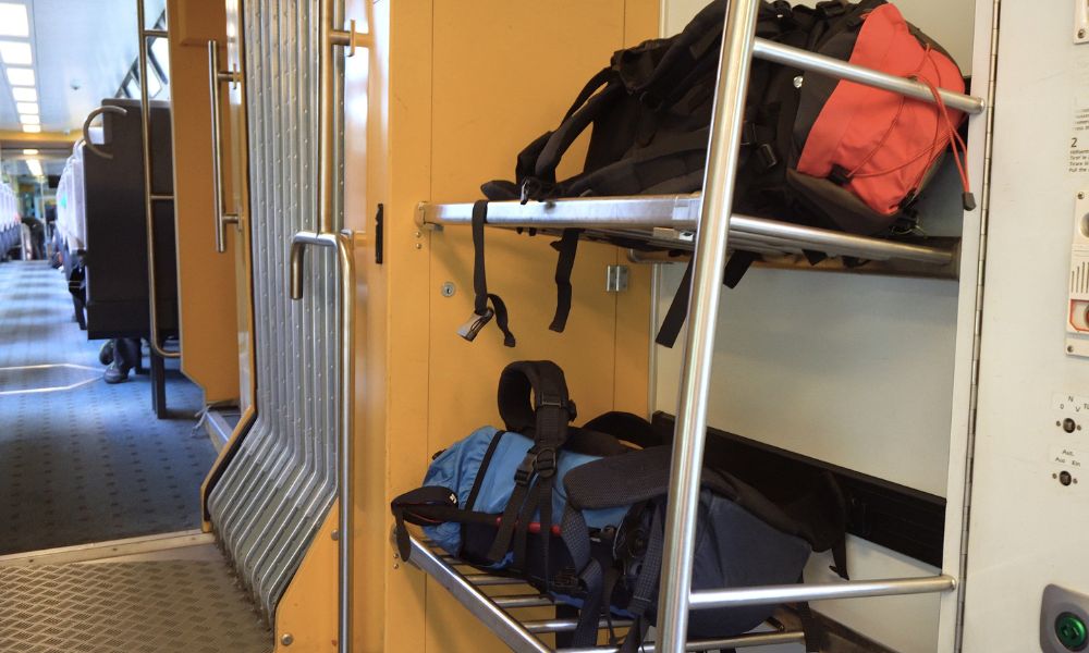 This is an image of some bags in a rack in the storage area of the train.