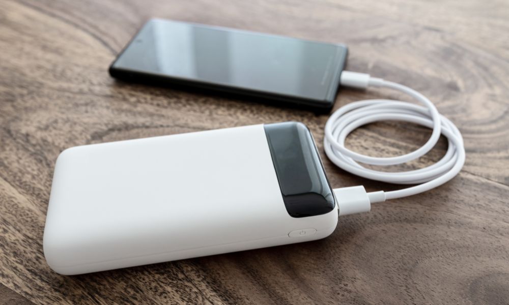 This is an image of a phone resting on a table connected to a power bank.