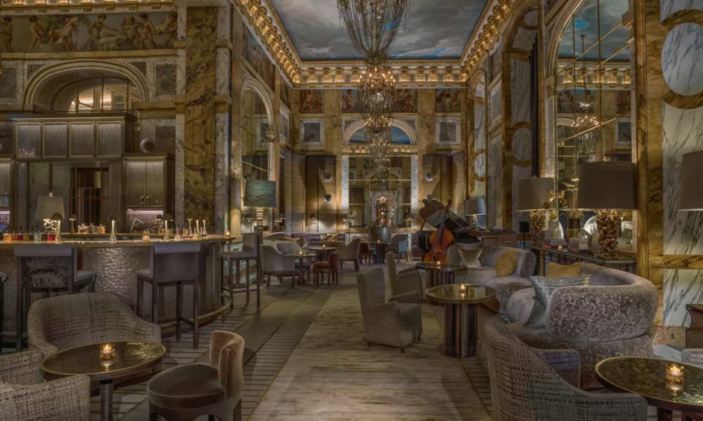 This is an image of a fancy 5-Star Hotel Bar in the Rosewood Hotel with a bunch of fancy sofa seating and gold detailing.