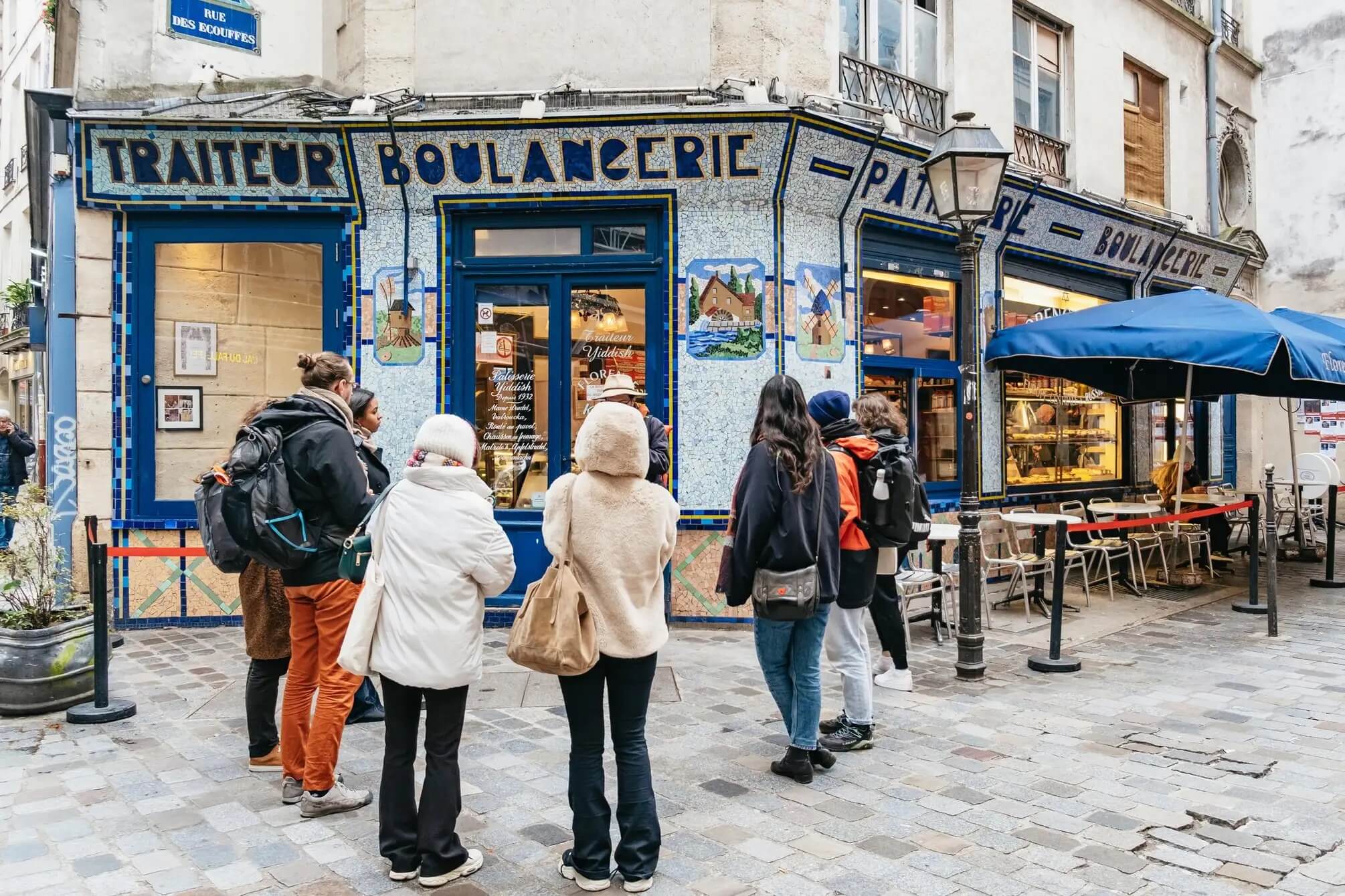 This shows the tour attendants hearing the guide in front of a Boulangerie.