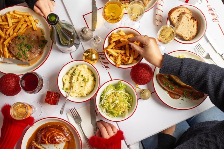 This is an image of a table full of delicious French food from a French restaurant called Boullion Pigalle.