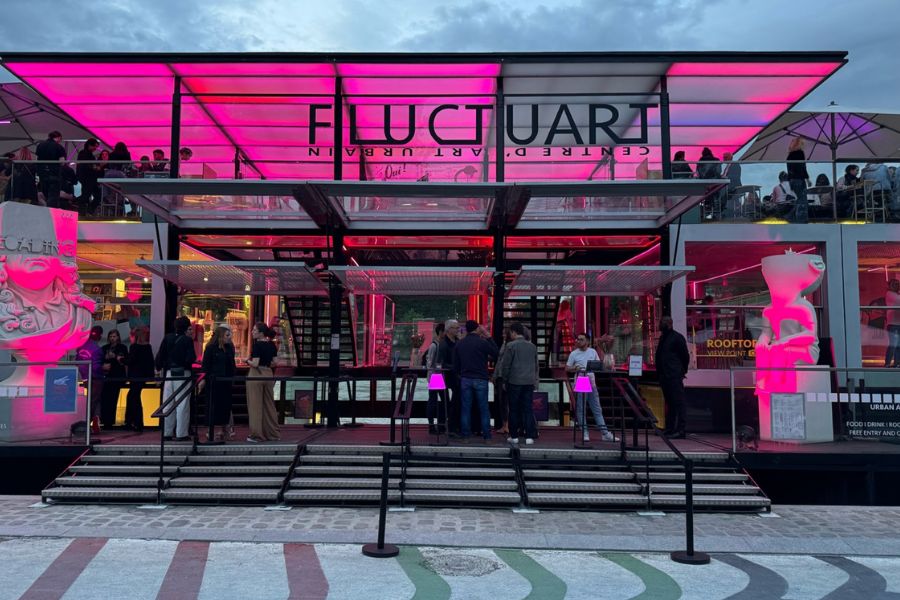 This is the front of the Fluctuart street art museum along the Seine with its clear glass entry and pink neon lighting.