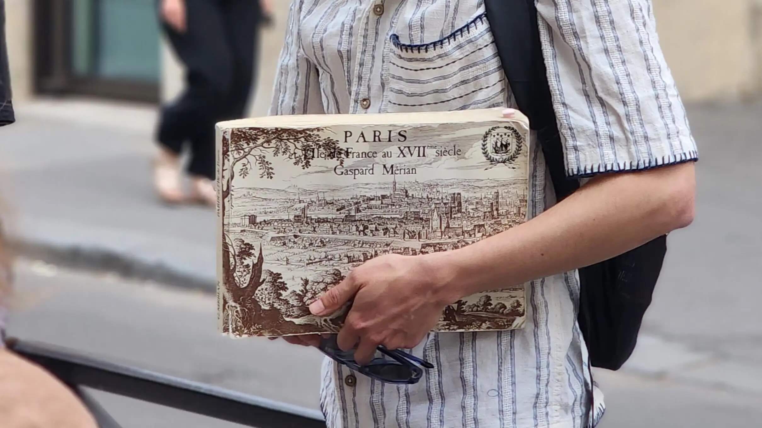 This picture shows the tour guide holding a book on Paris from the XVII century.