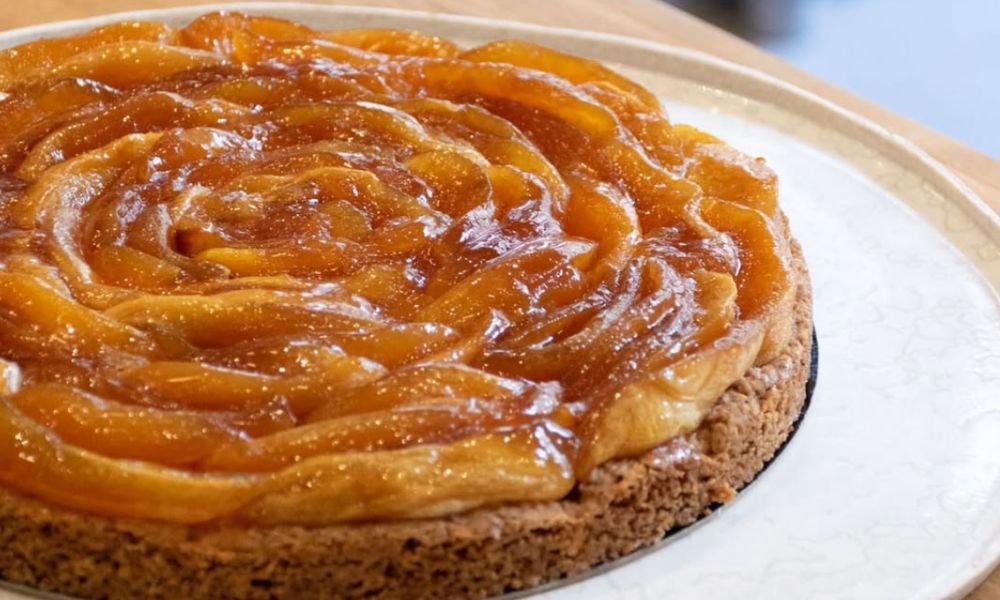 This is an image of a tarte tartin sitting golden on a plate.