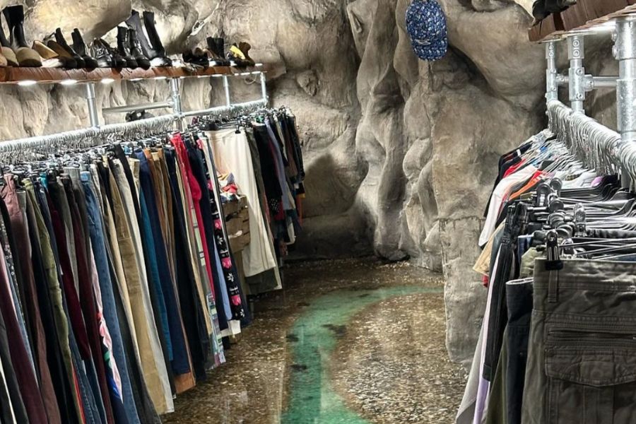 This is an image of an underground vintage store where the racks of clothes surround the edges of the room.