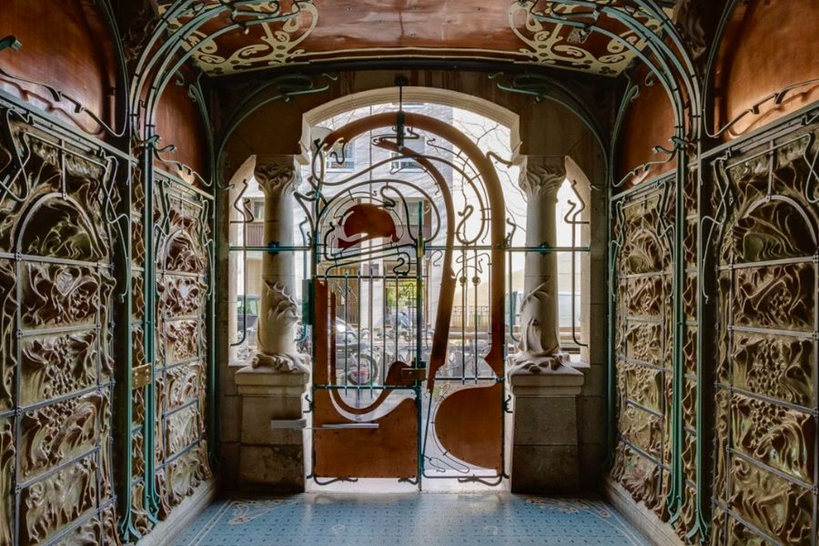 What to do in Paris During the Olympics: This is a picture of a very unique, artistic door entrance with statues and tiling.