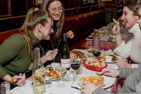 This is an image of group of friend's eating a nice meal together and laughing.