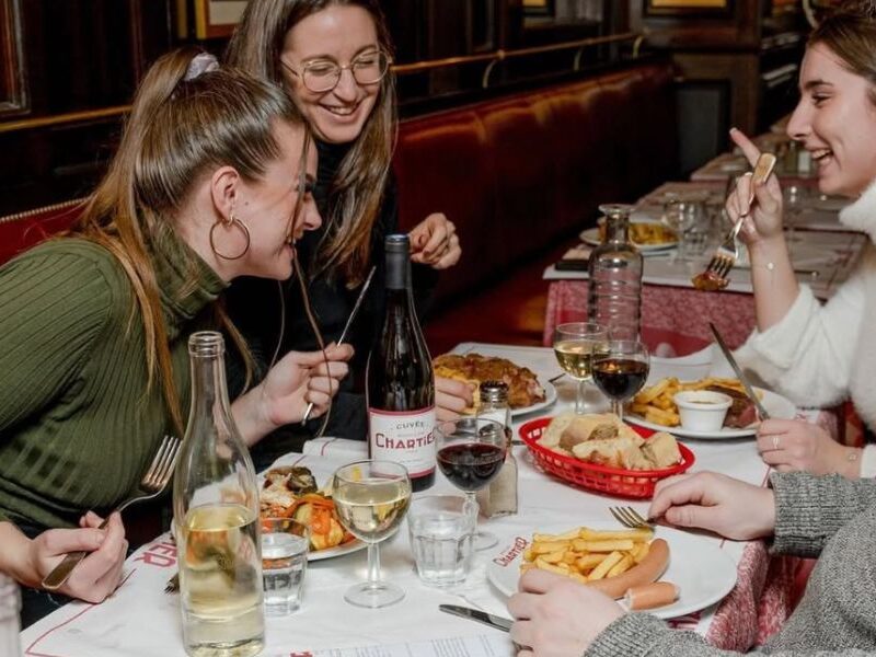 This is an image of group of friend's eating a nice meal together and laughing.